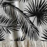 Manta tejida diseño botánico de distintos tipos de hojas tipo palmera en color negro.