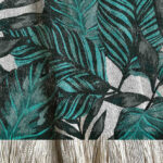 Manta tejida diseño botánico de distintos tipos de hojas tipo palmera en color y aqua.