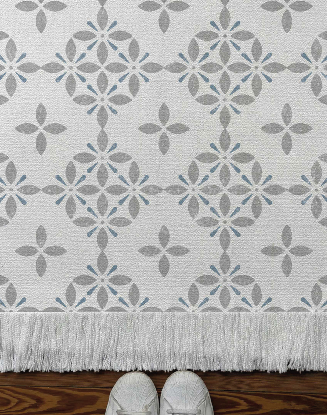 Alfombra tejida diseño geométrico, tipo mandala con hojas. Color gris y azul.