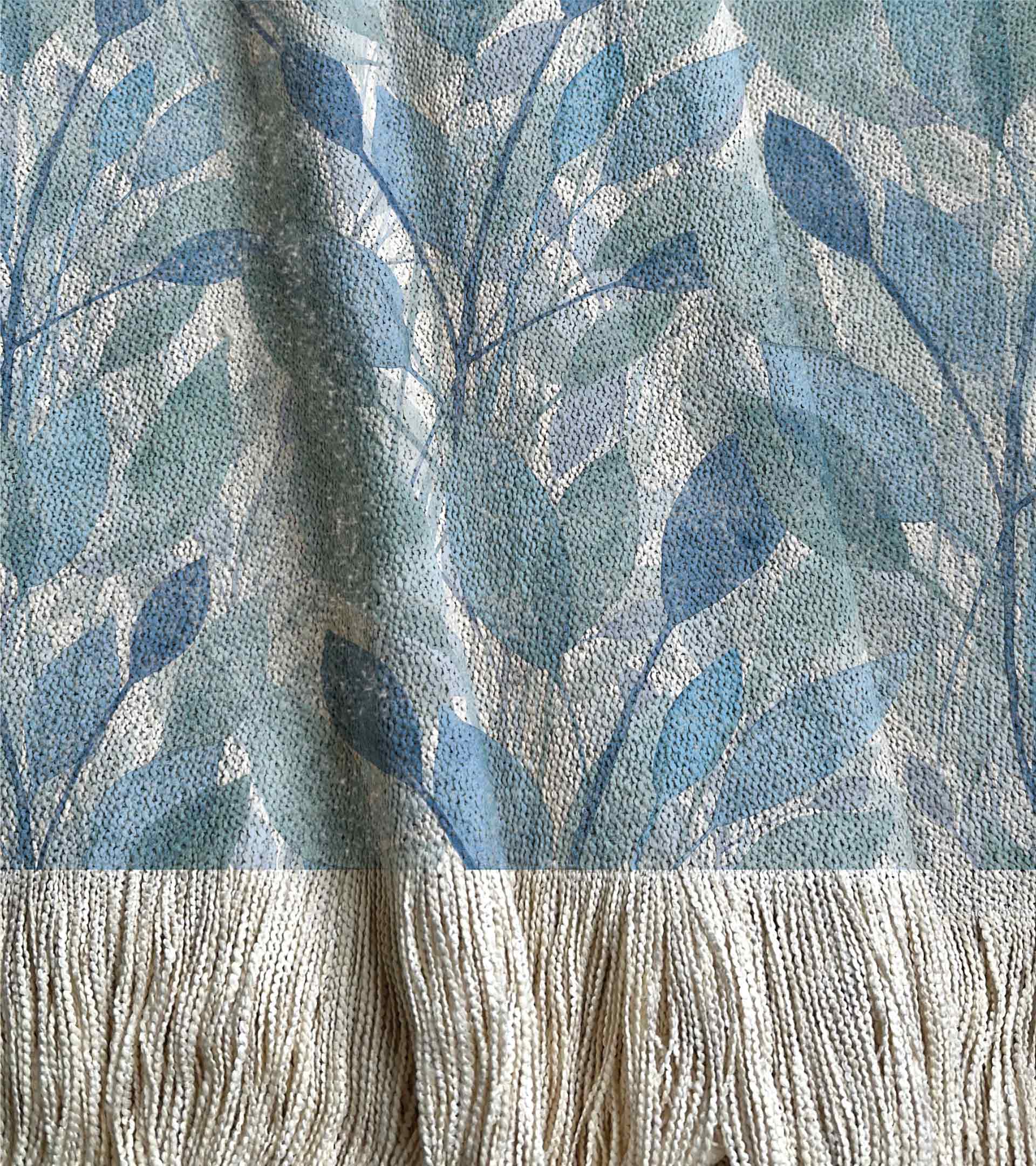 Manta tejida, diseño botanico con hojas grandes en acuarela, de color azul y celeste