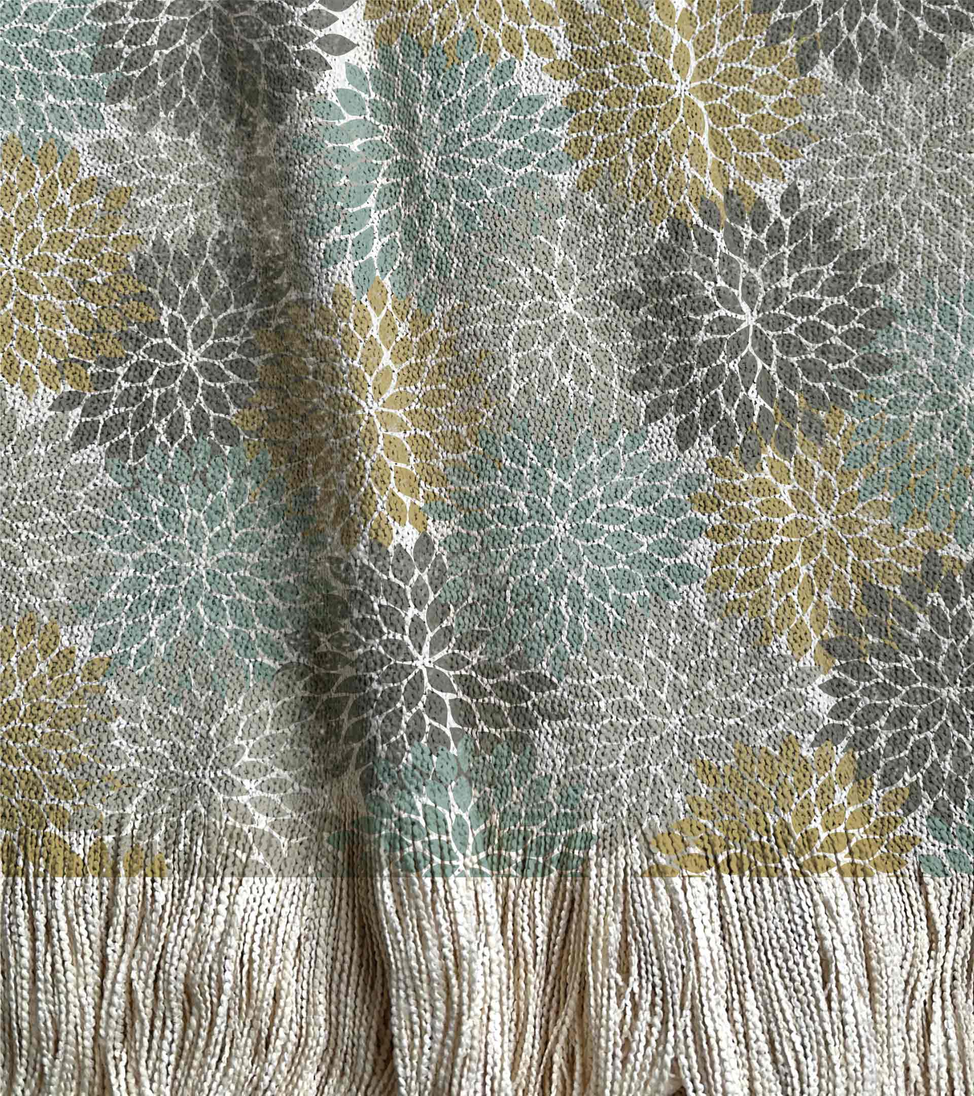 Manta tejida, con diseño botanico, floral en colores verdes, turquesas y grises
