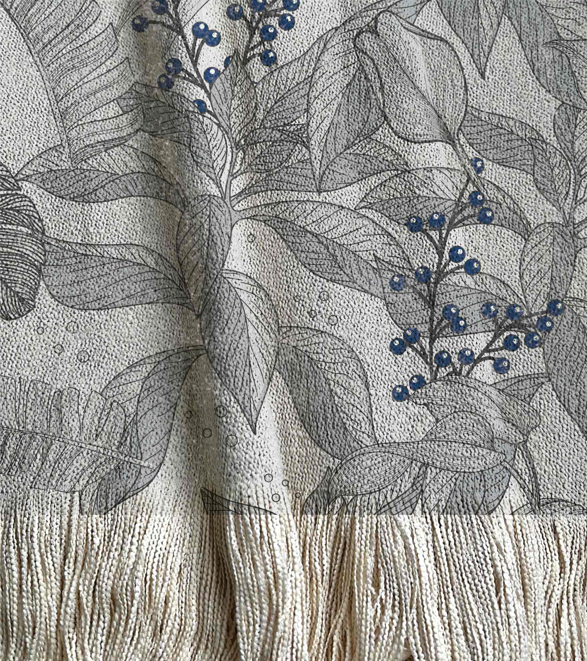 Manta tejida, diseño botanico. Hojas grandes decoro gris con frutos de color azul