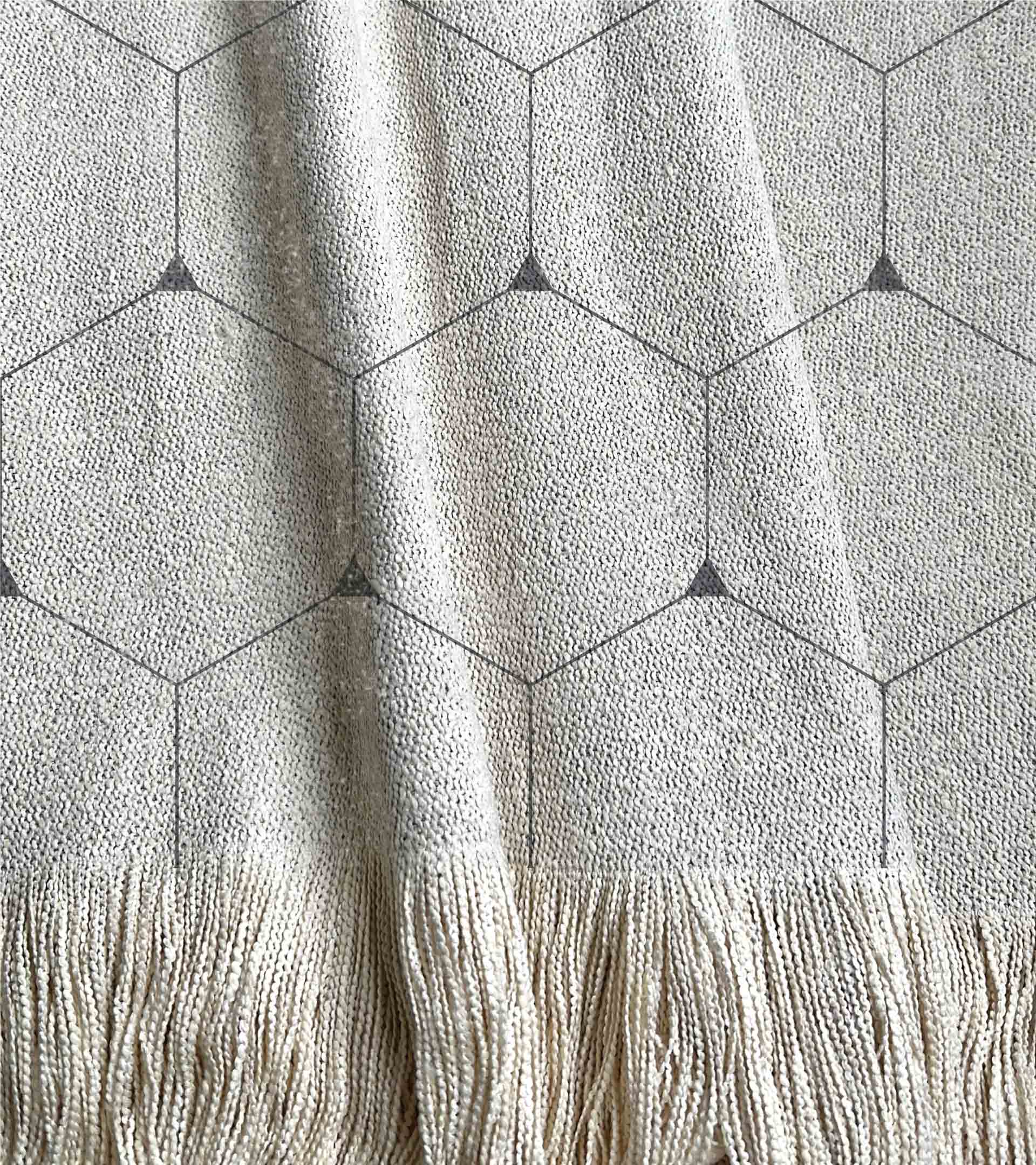 Manta tejida diseño geometrico, con lineas de color gris