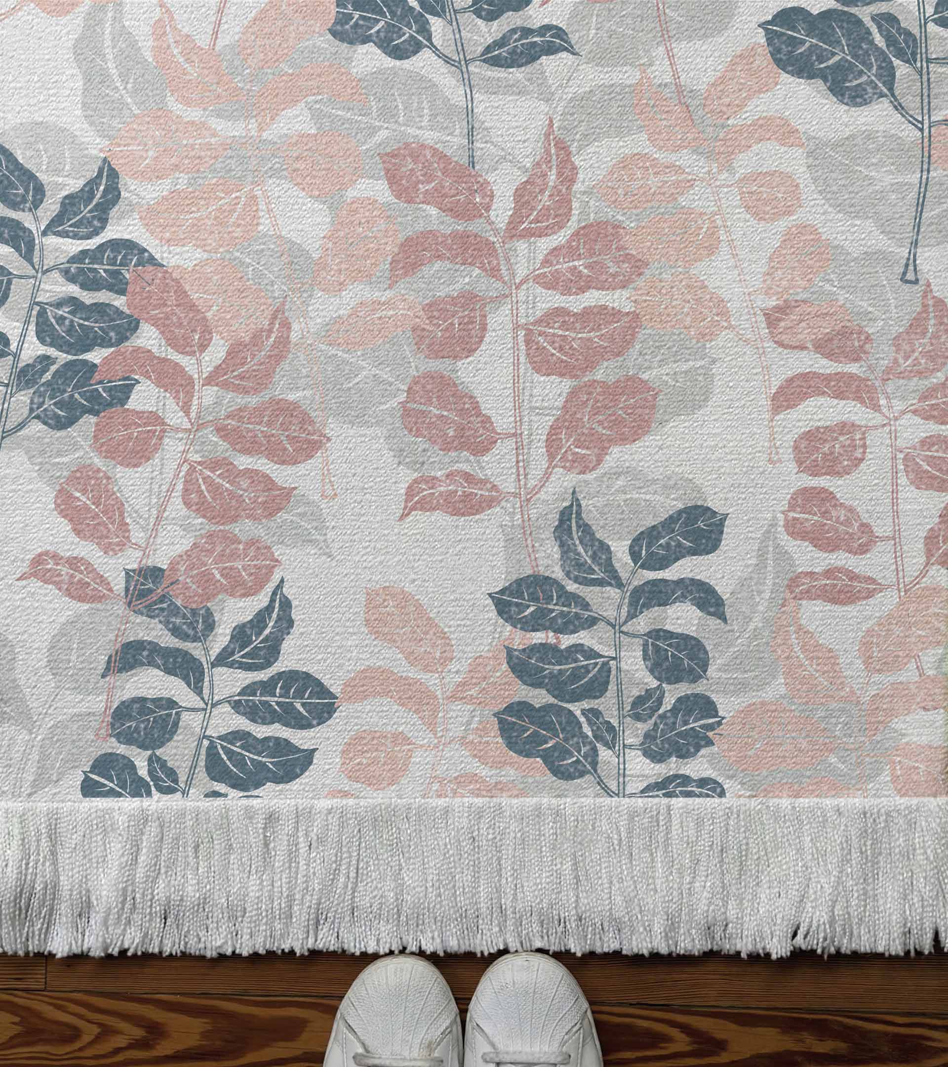 Alfombra tejida diseño botanico con ramas y hojas de color rosado, azul y gris