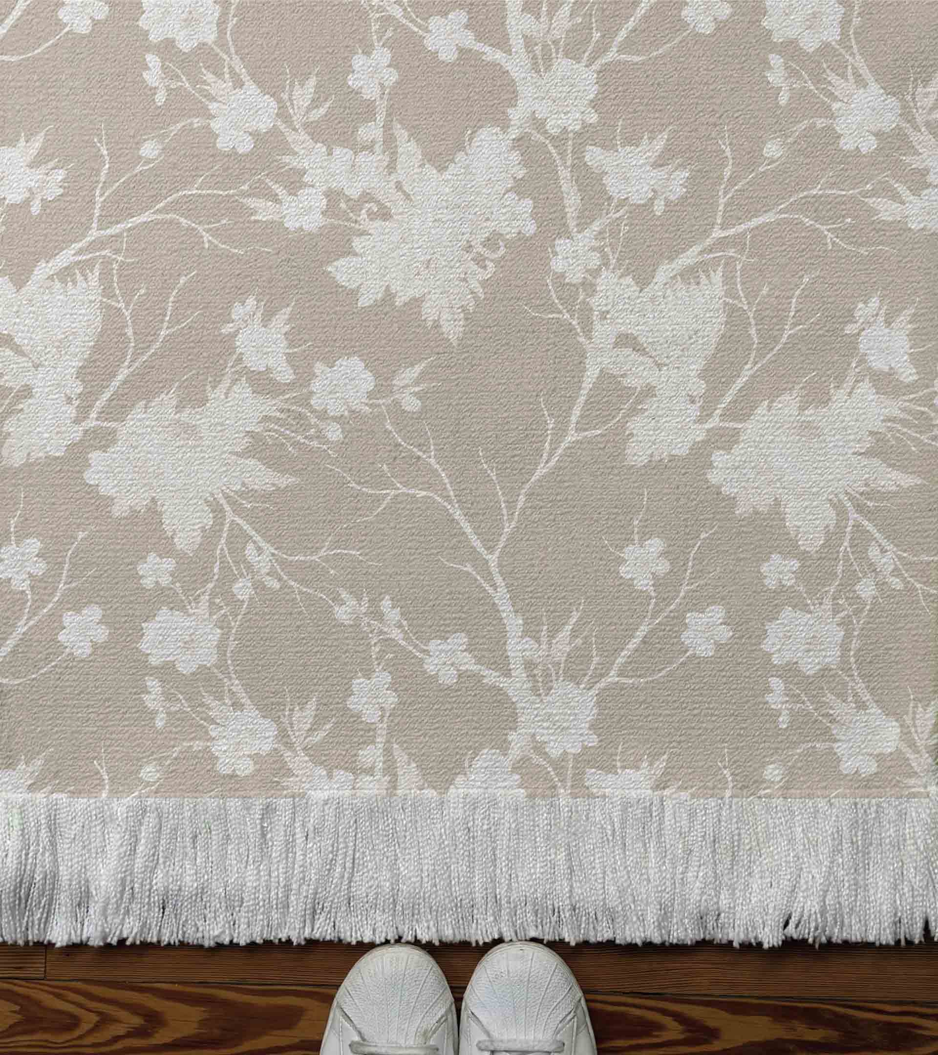 Alfombra tejida con diseño botanico con florones de color blanco y fondo beige