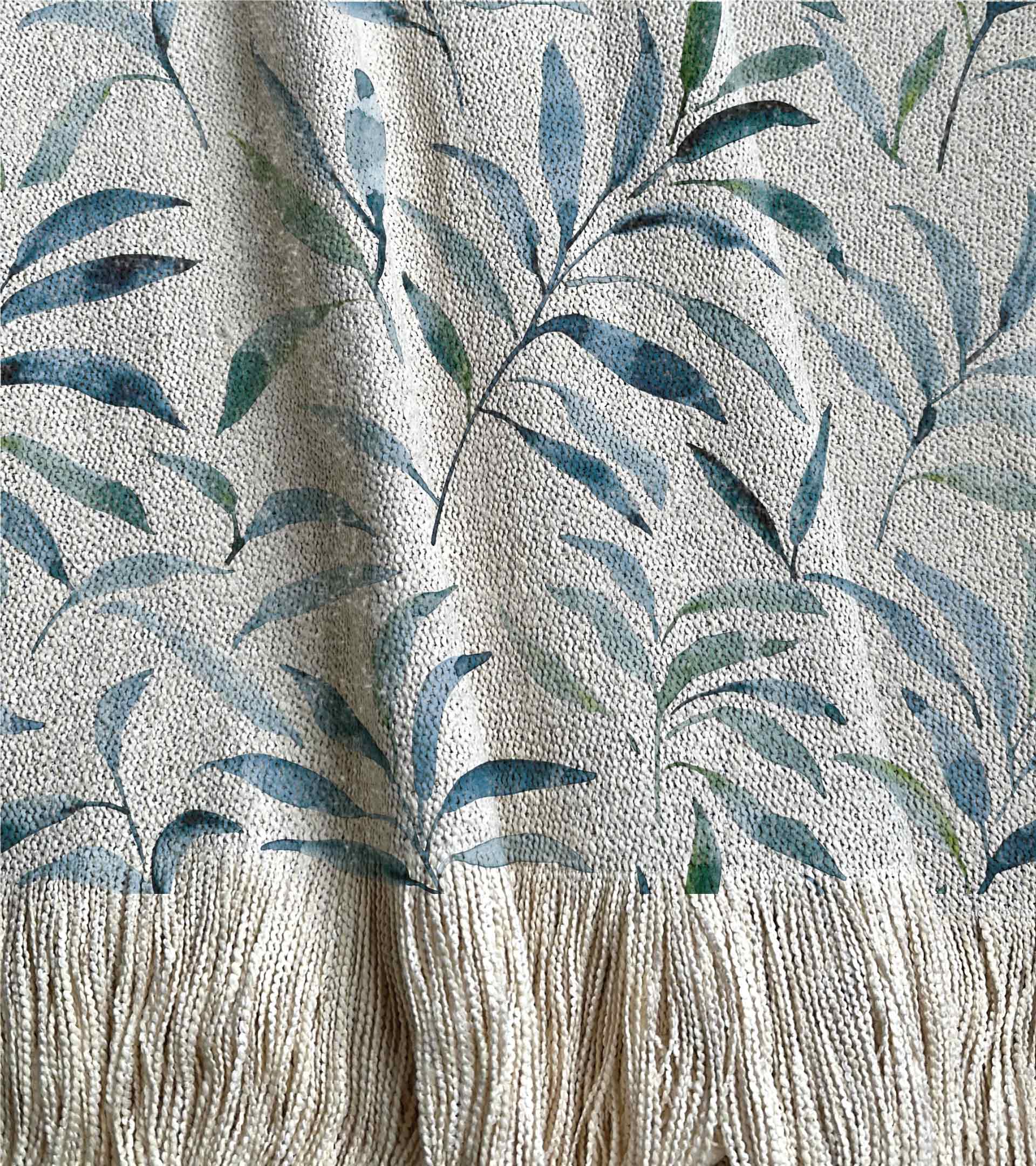 Manta tejida con un diseño botánico de hojas celestes y azules engomadas en acuarela