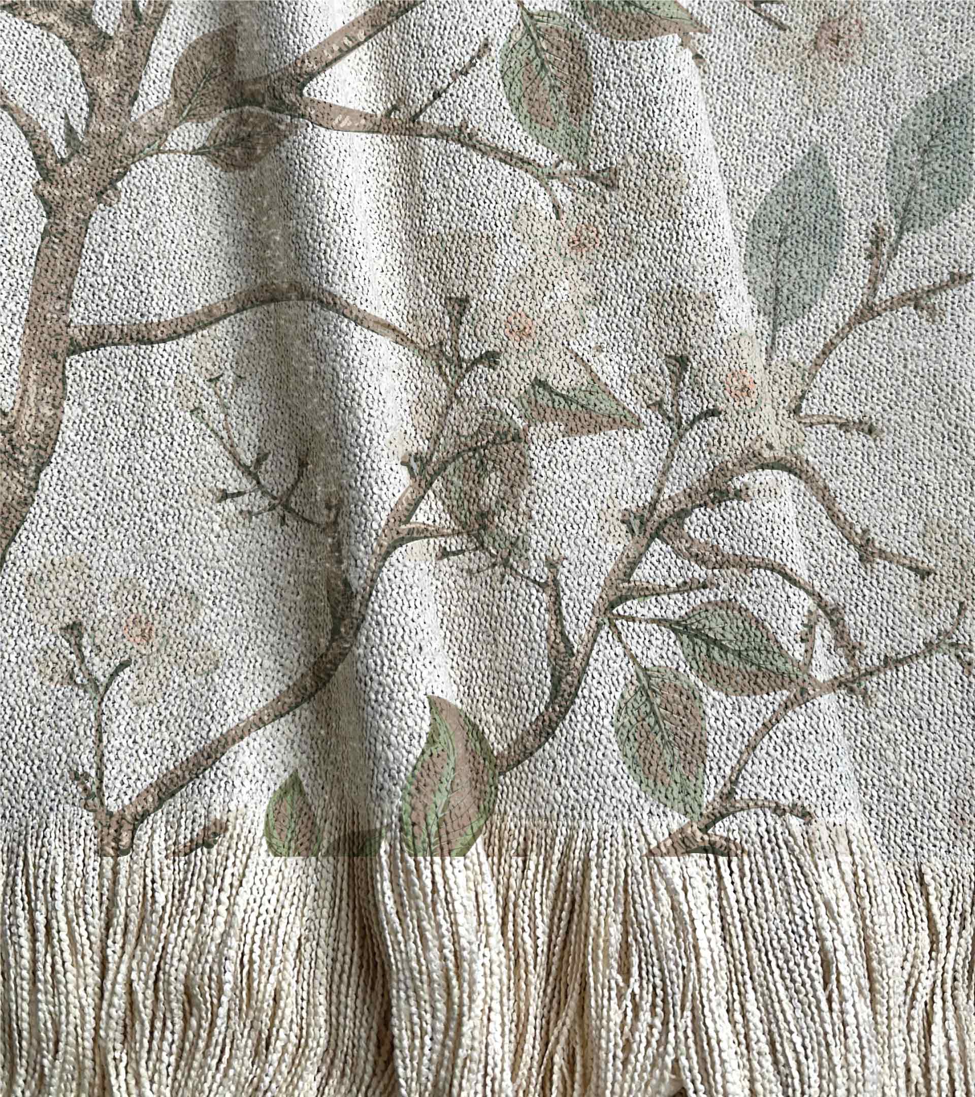 Manta tejida con diseño botanico de ramas con hojas verdes y flores de jazmín