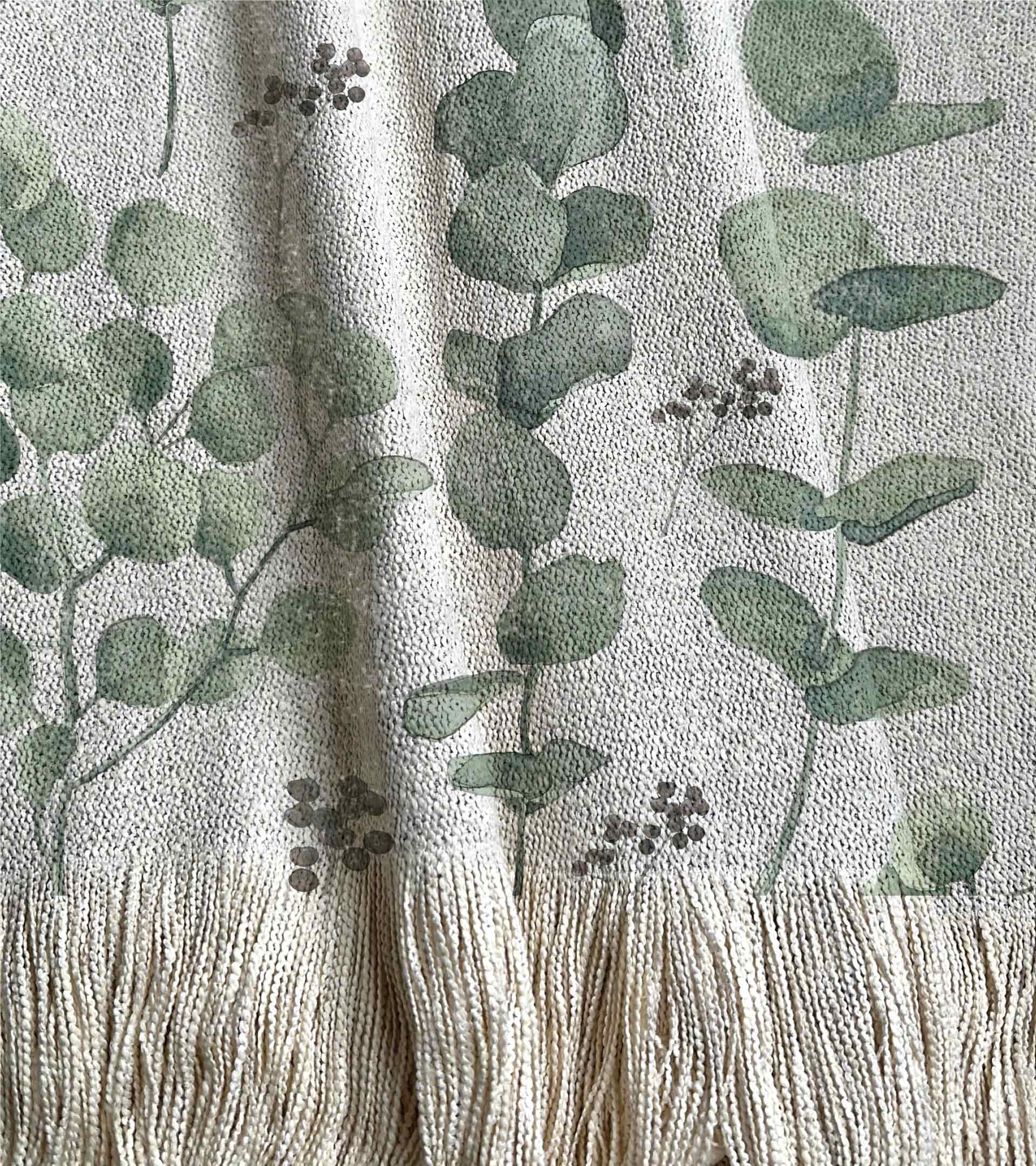 Manta tejida con diseño botanico de color verde con hojas y ramas de eucalipto en acuarela